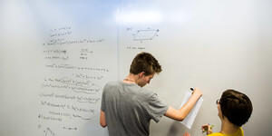 students use a whiteboard in a library study room