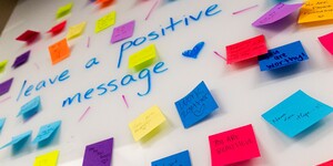 A whiteboard covered with colorful positive message post-it notes
