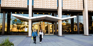 Two people walking outside of Hayden Library