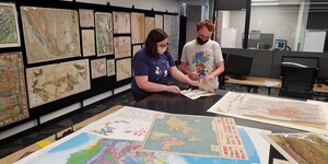 A student and staff member inspecting a map in the Map and Geospatial Hub.