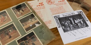 Archival photographs and materials displayed on a table.