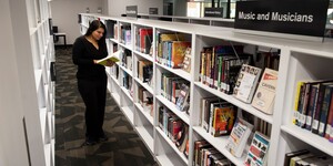 Student looking at a book in a library