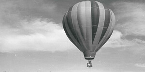 Image of a hot air balloon rising above campus buildings as part of the Thunderbird Classic balloon race.