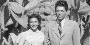 Rebecca Muñoz Gutierrez and Felix Joachim Gutierrez stand together in front of a large cactus.