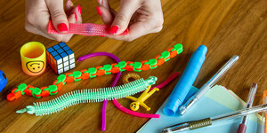Items from an activity kit include puzzles, colored pens, and other small toys.