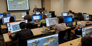 Geospatial workshop attendees use their computers to follow along with an instructor as he leads them through downloading information on geographic areas of interest.