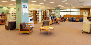 An open space with conversational and study seating and bookshelves in the back.