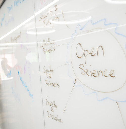 A librarian drawing on a whiteboard to illlustrate Open Science concepts.