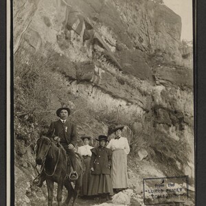 Black and white print of one man and three women (unidentified) on a trail.