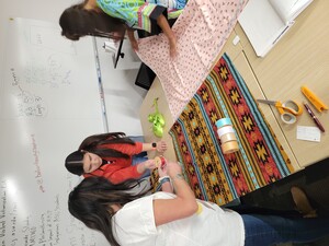 Labriola Student Worker, Baylee LaCompte, showing students how to measure and cut fabric. 