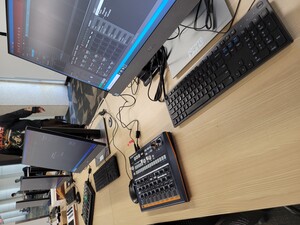 A desk with a computer connected to a MIDI controller. 