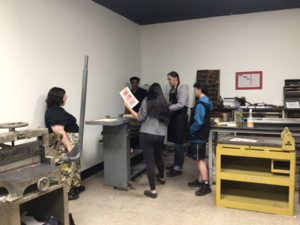 Photo of Professor Meders helping students create an original print in his print shop.