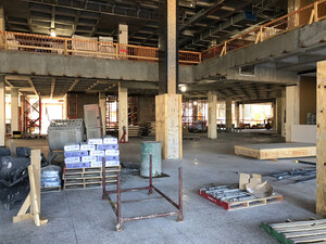 Photo of Hayden Library construction site, showing the lobby of Level 1, with the original columns in the foreground and the new elevator shaft in the background