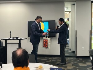 Bryan Newland, Assistant Secretary of the Interior for Indian Affairs receiving a Labriola Tote from Director Alex Soto. The tote says "Indigenous Libraries = Cultural Resilience"