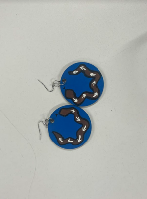 Two blue wooden circle earrings painted blue with a black and white snake design