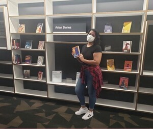 Myra standing in front of Asian American Voices book display.