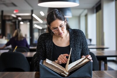 A student views a book from Distinctive Collections in the Wurzburger Reading Room.