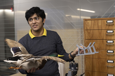 Student holds a taxidermy mallard and a 3D printed stand