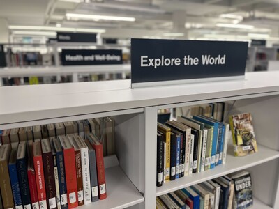 Books displayed on bookshelves under "Explore the Word" shelf topper 