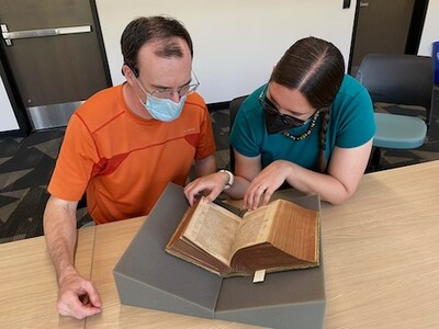 Professors Mark Cruse and Hannah Barker looking at the Chronicon 