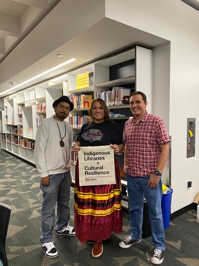 Pictured left to right: Director Alex Soto (Tohono O'odham), Elder in Residence Esther Nystrom (Diné), and Sr. Program Coordinator Eric Hardy (Diné). Esther holds a Labriola Center tote bag that says, "Indigenous Libraries = Cultural Resilience."
