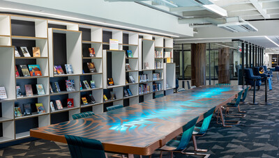 Library space with books on shelves and a long table 