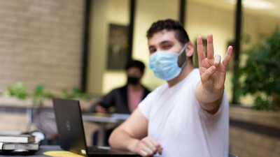 Student wearing a face covering in the library